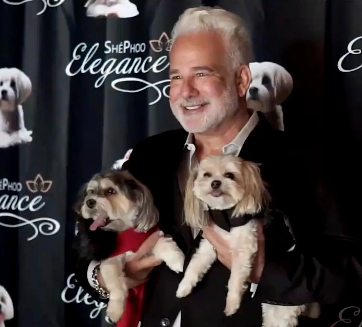A ShePhoo supporter holding two small dogs at a ShePhoo Elegance event